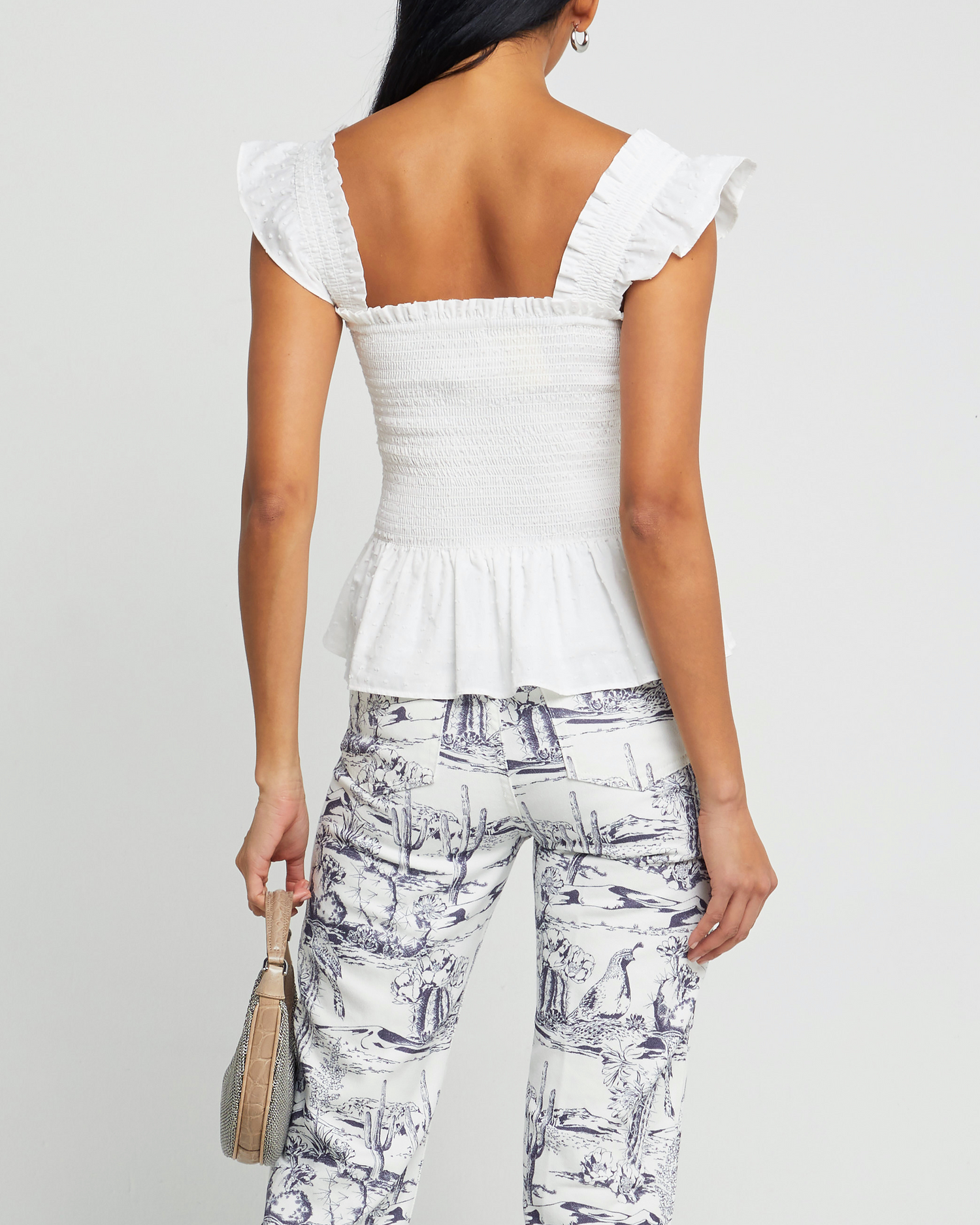 Second image of Calypso Top, a white sleeveless top, ruffle cap sleeves, smocked bodice