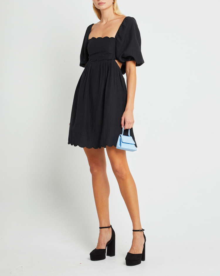 Fourth image of April Dress, a black mini dress, open back, tie back, short sleeve, scalloped hem