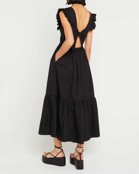 Second image of Stella Dress, a black midi dress, front buttons, ruffle sleeve, open back, tied ribbon, bow, tiered