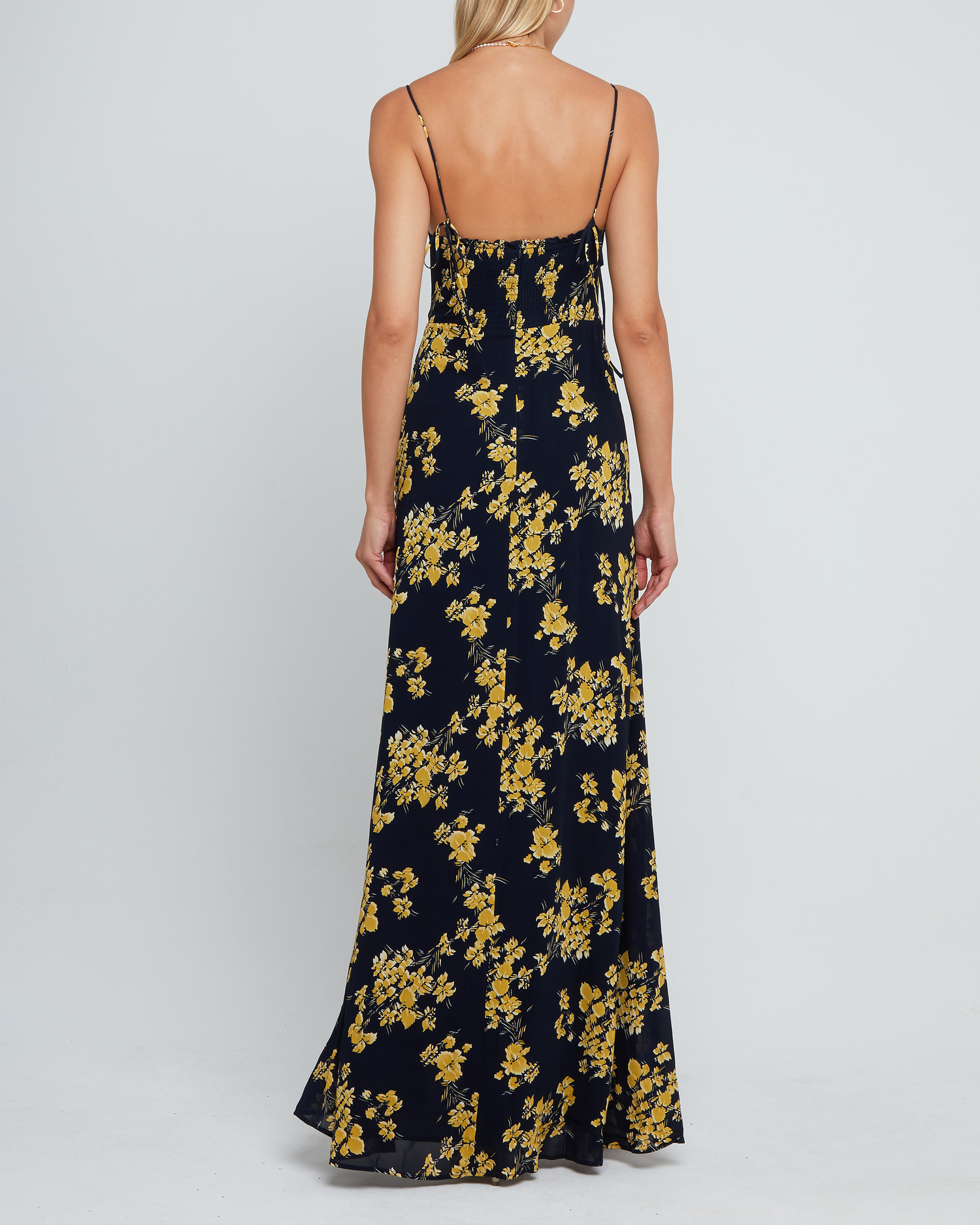 Fourth image of Delphi Dress, a navy and yellow floral maxi-length bridesmaid dress with sweetheart neckline, cup detail, side slit, cupped sweetheart neckline, back zipper, back smocking, and adjustable tie string straps