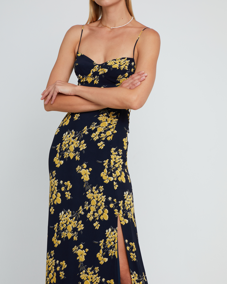 Seventh image of Delphi Dress, a navy and yellow floral maxi-length bridesmaid dress with sweetheart neckline, cup detail, side slit, cupped sweetheart neckline, back zipper, back smocking, and adjustable tie string straps